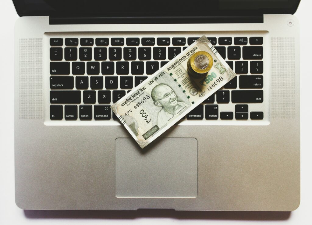 Laptop with money on top of it