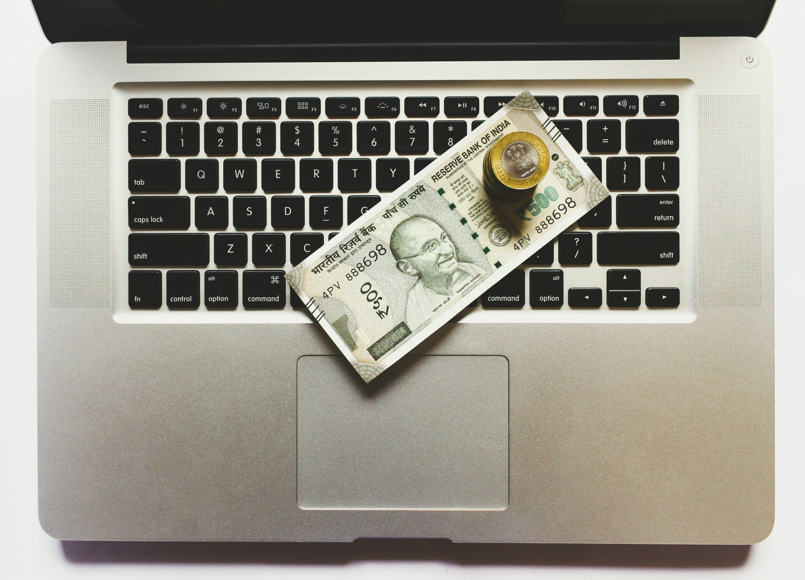 Laptop with money on top of it
