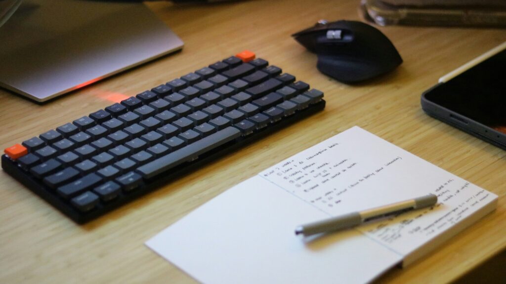 Laptop with pen and paper fixing copywriting mistakes